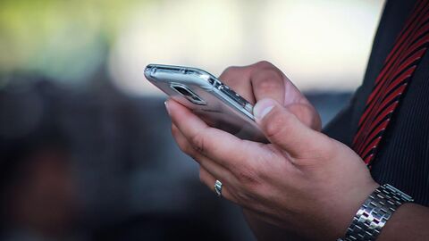 Kontakt (Symbolbild) Mann tippt auf seinem Mobiltelefon.