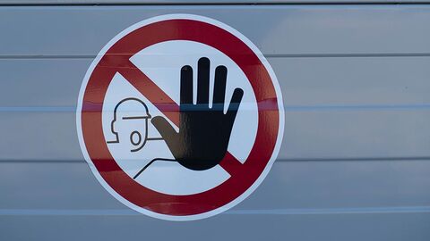 Warnung (Symbolbild) Warnschild, auf dem ein im Umriss dargestellter Bauarbeiter eine schwarze offene Hand hochhält.