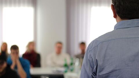 Ausbilder steht im Frontalunterricht vor einigen Auszubildenden.