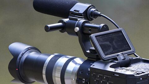 Das Foto zeigt einen Bildausschnitt einer Videokamera vor graugrünem unscharfen Hintergrund.