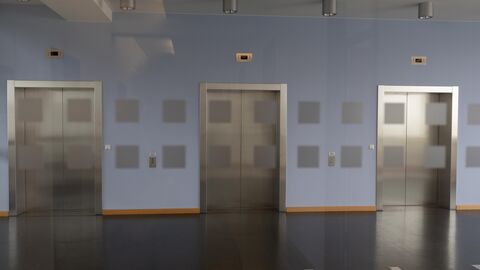 in einem leeren Flur sind drei geschlossene Aufzugstüren zu sehen.