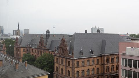 Der Blick führt aus einem Obergeschoss des Oberlandesgerichts über die Dächer der umliegenden Häuser, im Hintergrund sind Hochhäuser zu sehen.