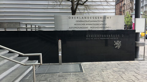 Der Blick fällt auf die Schrifttafel "Oberlandesgericht - Generalstaatsanwaltschaft - Hessischer Anwaltsgerichtshof - Justizprüfungsamt Prüfungsabteilung 1" im Eingangsbereich des Gerichtsgebäudes D. 