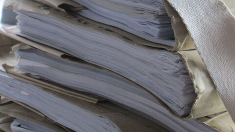 Das Bild zeigt nachlässig aufeinandergestapelte Akten.