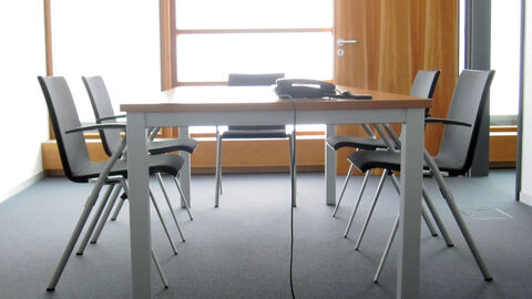 Besprechungszimmer Ein Tisch und fünf Stühle stehen in einem Besprechungsraum.