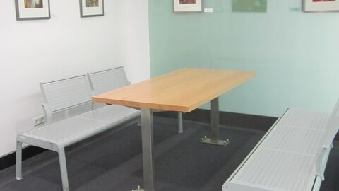 Tisch und zwei Bänke im Gesprächsbereich für Prozessbeteiligte.