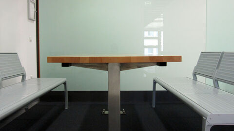 Ein Tisch und zwei Bänke stehen im Gesprächsbereich für Prozessbeteiligte.