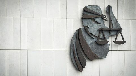 Darstellung einer Justitia mit Waage und Augenbinde an einer Häuserwand.