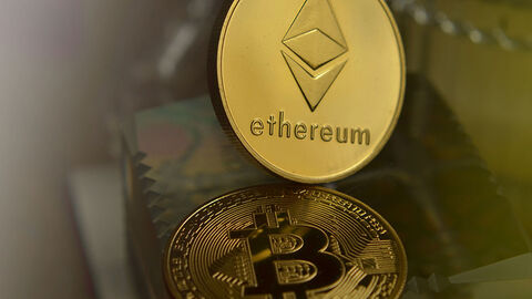 Ethereum- und Bitcoin-Münzen vor unscharfem Hintergrund.