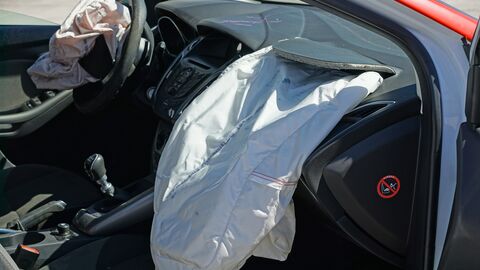 Innere Front eines Fahrzeugs mit aufgegangenem Airbag.