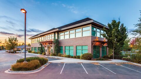 Leere Parkbuchten vor einem Gebäude.