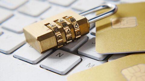 Datensicherheit (Symbolbild) Auf einer Tastatur liegen ein Zahlenschloss und zwei Chipkarten.