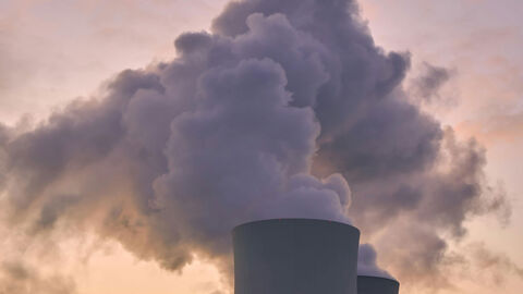 Der Turm eines Kraftwerkes mit einer großen Wolke.