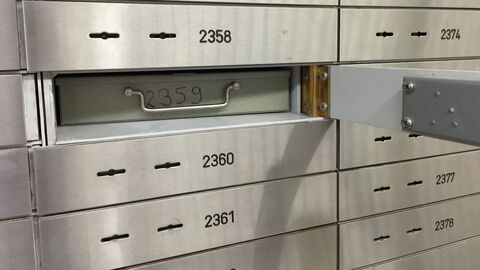 Ausschnitt eines Schranks mit Schließfächern, eines davon geöffnet.