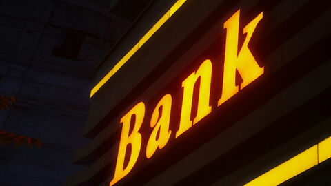 Bank (Symbolbild) Ein Schriftzug -Bank- leuchtet im Dunkeln.